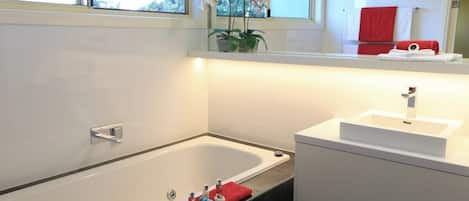 Bathtub, hair dryer, towels, shampoo
