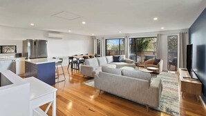 A modern living space with a kitchen, dining area, and seating area.