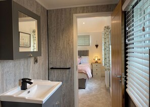 A bathroom with a sink, mirror, and towel rack.