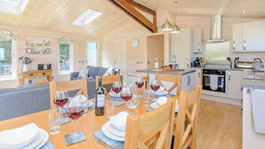 A spacious kitchen with a dining area, wooden beams, skylights, and modern appliances. - Luxurious lodge with stunning countryside views. (Ashover)