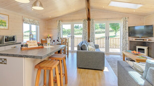 A cabin interior with a kitchen, dining area, and living room. - Luxurious lodge with stunning countryside views. (Ashover)