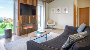 Una sala de estar moderna con chimenea, un sofá, una mesa de centro y un televisor.