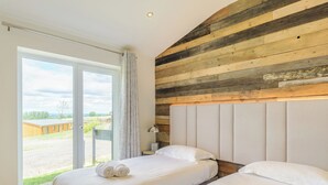 Un dormitorio con dos camas, un ventanal y vistas al exterior.