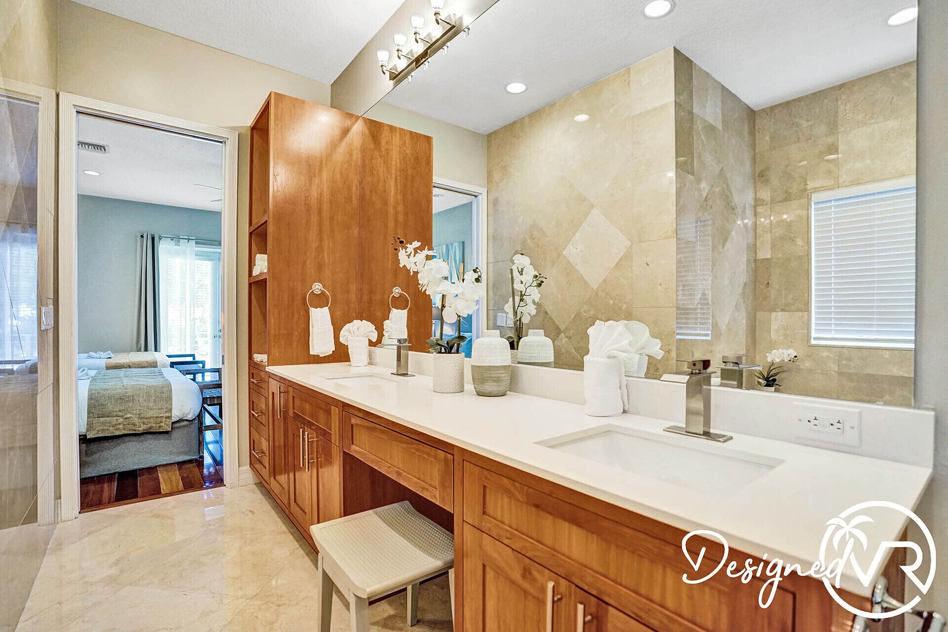 A modern bathroom with a large mirror, wooden vanity, and a bench.