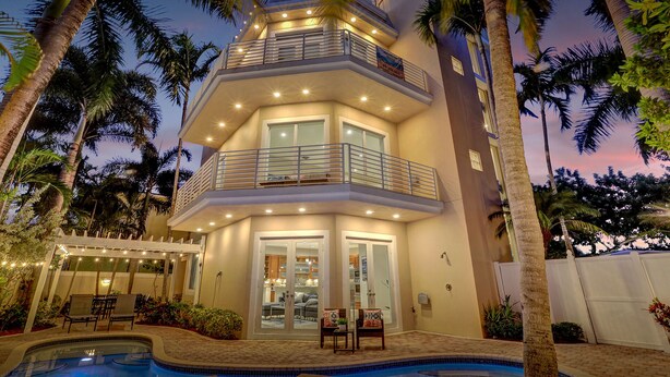 A multi-story building with balconies, a swimming pool, and palm trees. - The Nia Tower Ultimate Beach House (Pompano Beach)