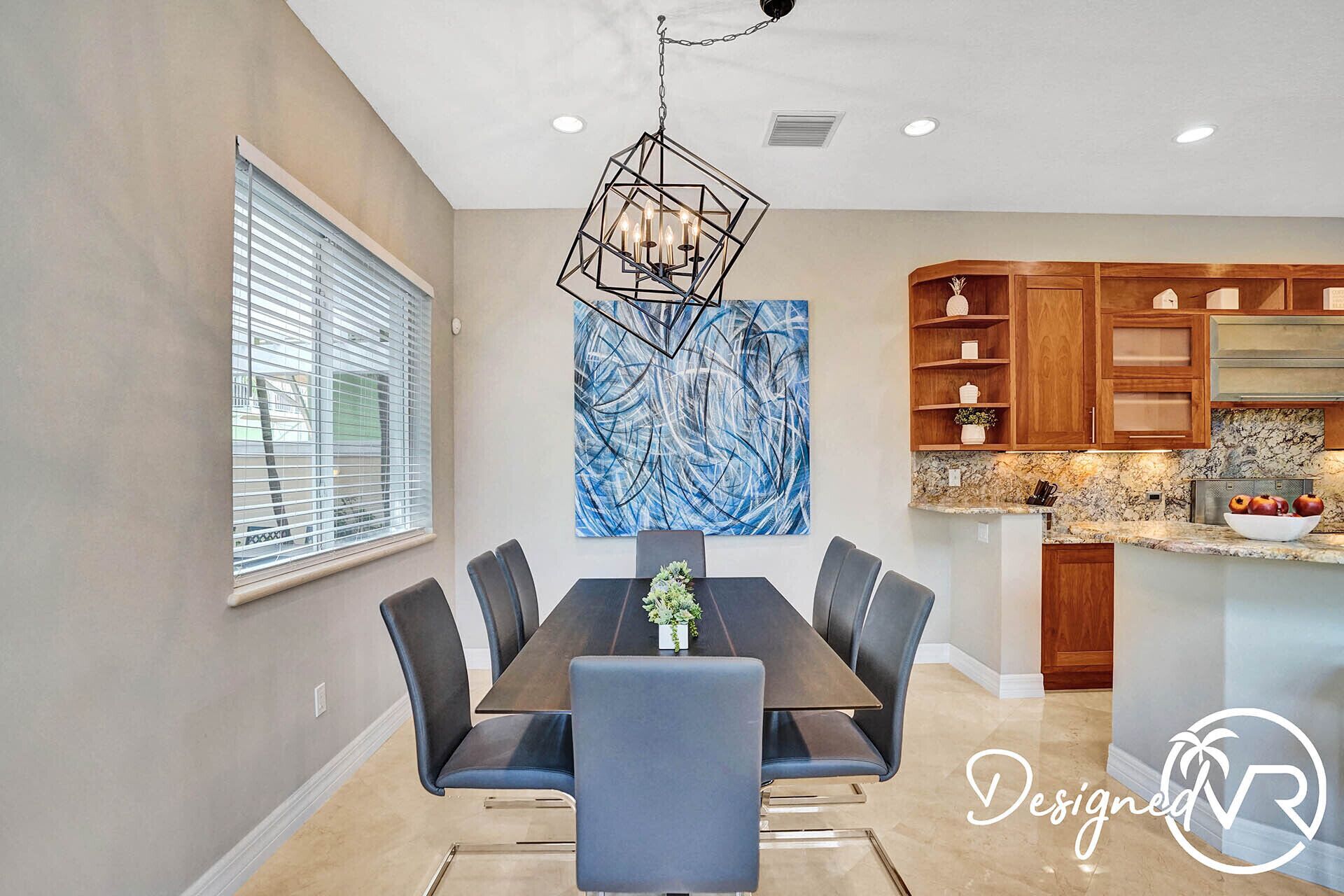 A modern dining area with a rectangular table, six chairs, and a geometric pendant light.