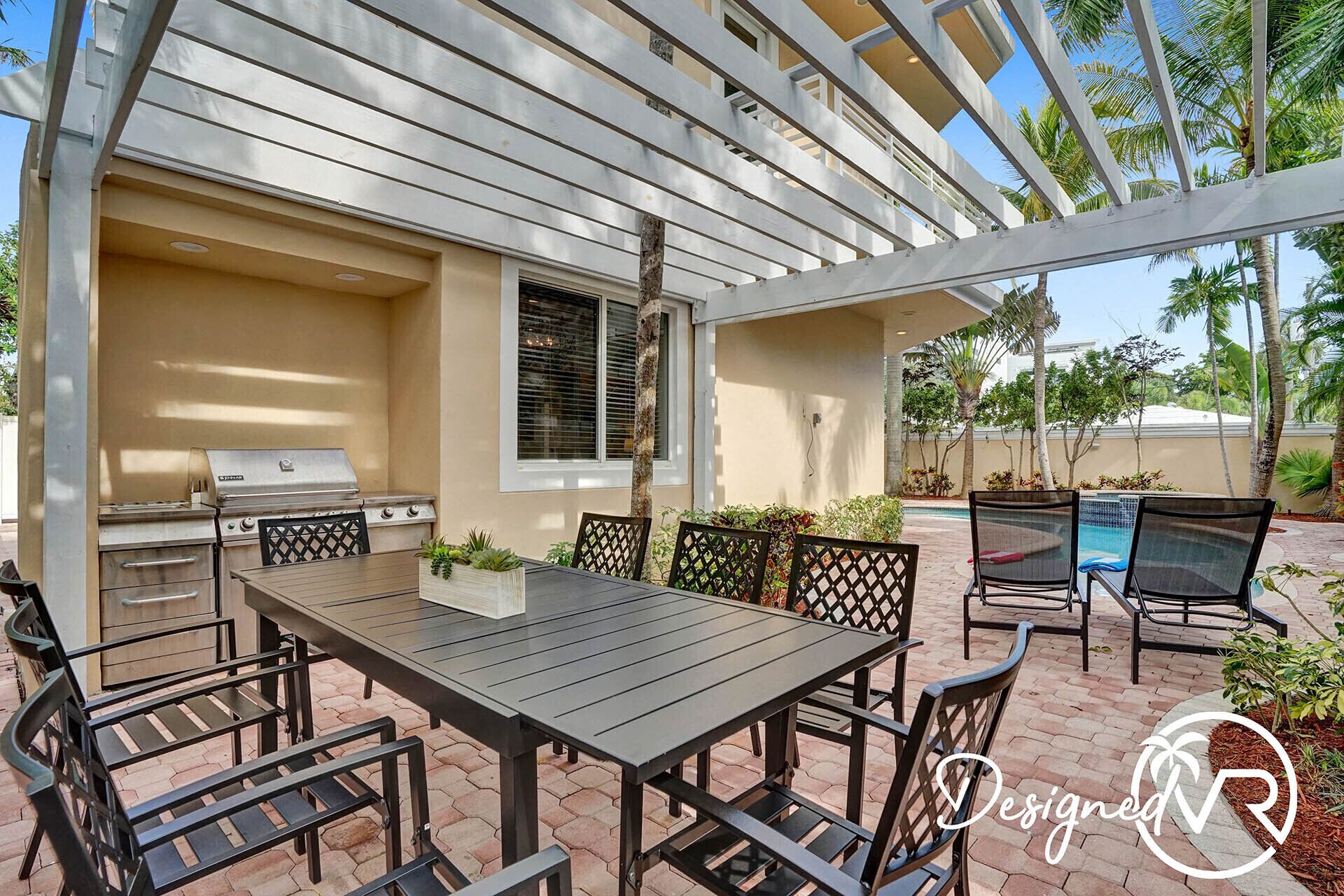 An outdoor patio with a grill, table, and chairs.