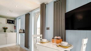 Une cuisine moderne équipée d’un four à micro-ondes, d’un évier et d’un coin repas avec une table et des chaises.