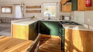 Una cocina compacta con lavamanos, estufa y armarios de madera.