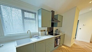 Una cocina moderna con ventana, lavabo y horno empotrado.