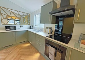 A modern kitchen with a microwave, kettle, and stove.
