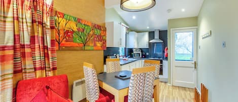 Une cuisine moderne avec des meubles blancs, un four à micro-ondes et une cuisinière.
