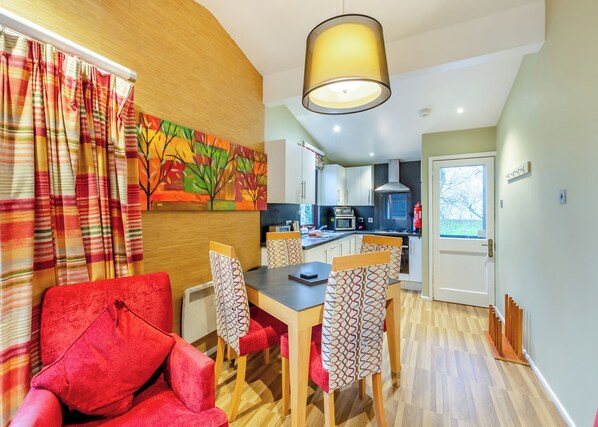 A modern kitchen with white cabinets, a microwave, and a stove. - Cosy traditional lodge with one double and one twin. (Millom)