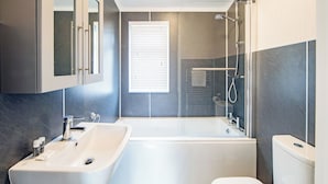 Ein modernes Badezimmer mit Badewanne, Waschbecken und Toilette.
