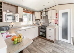 A modern kitchen with a microwave, toaster, stove, and sink.