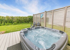 A hot tub with a wooden deck, a wooden fence, and a sign that reads 'YOUR DREAM HOLIDAY HOME IS HERE.' - Sandy Pebble Deluxe (Pet) (Looe)