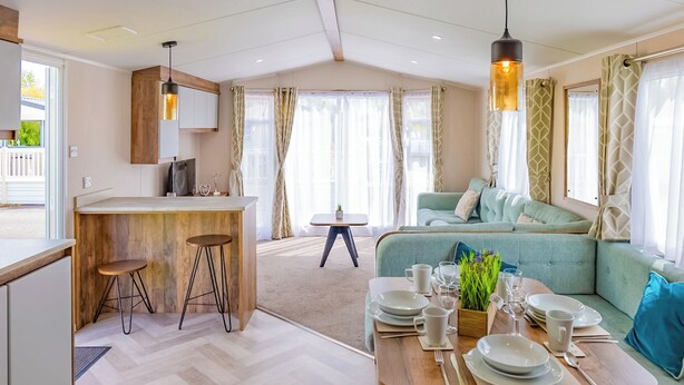 Ein modernes Wohnzimmer mit Sofa, Esstisch und einer Küchenzeile mit Barbereich.