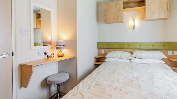 A hotel room with a bed, a bedside table, a lamp, a mirror, and a small stool. - 1 bedroom accommodation in Alyth, Perthshire (Alyth, Perthshire)