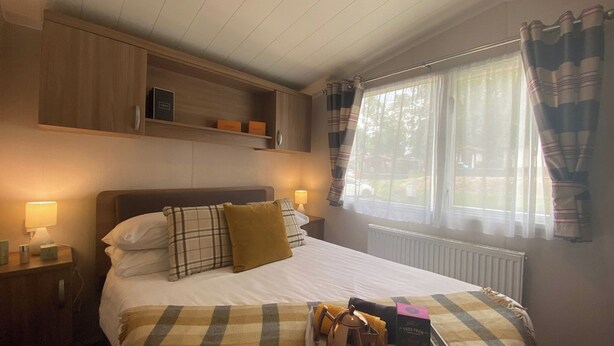 A bedroom with a bed, bedside lamps, a window with curtains, and a tray with breakfast items. - 2 bedroom accommodation in Snowdonia (Snowdonia)