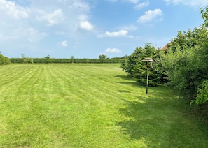 A well-maintained grassy field with a birdhouse and dense foliage. - 2 bedroom accommodation in Palgrave, Diss (Palgrave, Diss)