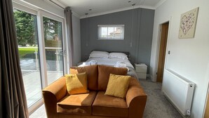 A bedroom with a sofa, a bed, a window, and a radiator. - 1 bedroom accommodation in Hawes, (Hawes,)
