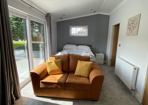 A bedroom with a sofa, a bed, a window, and a radiator. - 1 bedroom accommodation in Hawes, (Hawes,)