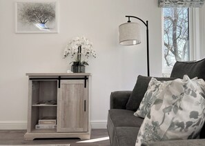 A living room with a grey sofa, a wooden cabinet with a sliding door, a floor lamp, and a framed picture on the wall. - 2 bedroom accommodation in Chipping (Chipping)