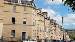 A row of traditional terraced houses with a sign indicating 'Portland Place'. - Stunning one bed apartment in central location - Pass the Keys (Bath)