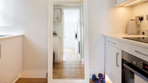 A modern kitchen with white cabinetry, a coffee maker, and a digital oven. - Chic Apartment, Steps away from King's Rd Chelsea - Pass the Keys (London)