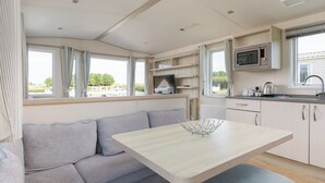 A compact kitchenette with a microwave, sink, and storage cabinets.