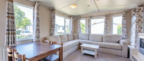 Ein gemütlicher Wohnbereich mit einer Couch, einem Esstisch mit Stühlen und einem Kamin.