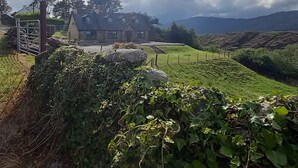 A stone house with a stone gate, surrounded by lush greenery and a stone wall. - Cuckoo Tree House, Glengarriff, Beara Peninsula (Glengarriff)