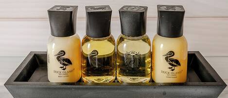 Four bottles of Duck Island body lotion, shower gel, and conditioner on a black tray.