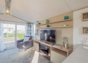A modern living room with a TV, sofa, and fireplace.