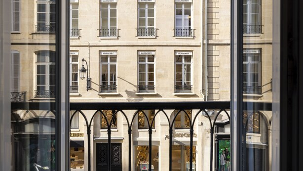 Un edificio de varios pisos con varias tiendas, incluyendo un letrero visible de 'BURBERRY'.