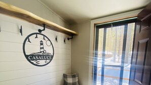 Tunnelmallinen huone, jossa on penkki, seinälle kiinnitetty kyltti, jossa lukee ”CASALUQUE”, ja ovi, joka johtaa ulos.
