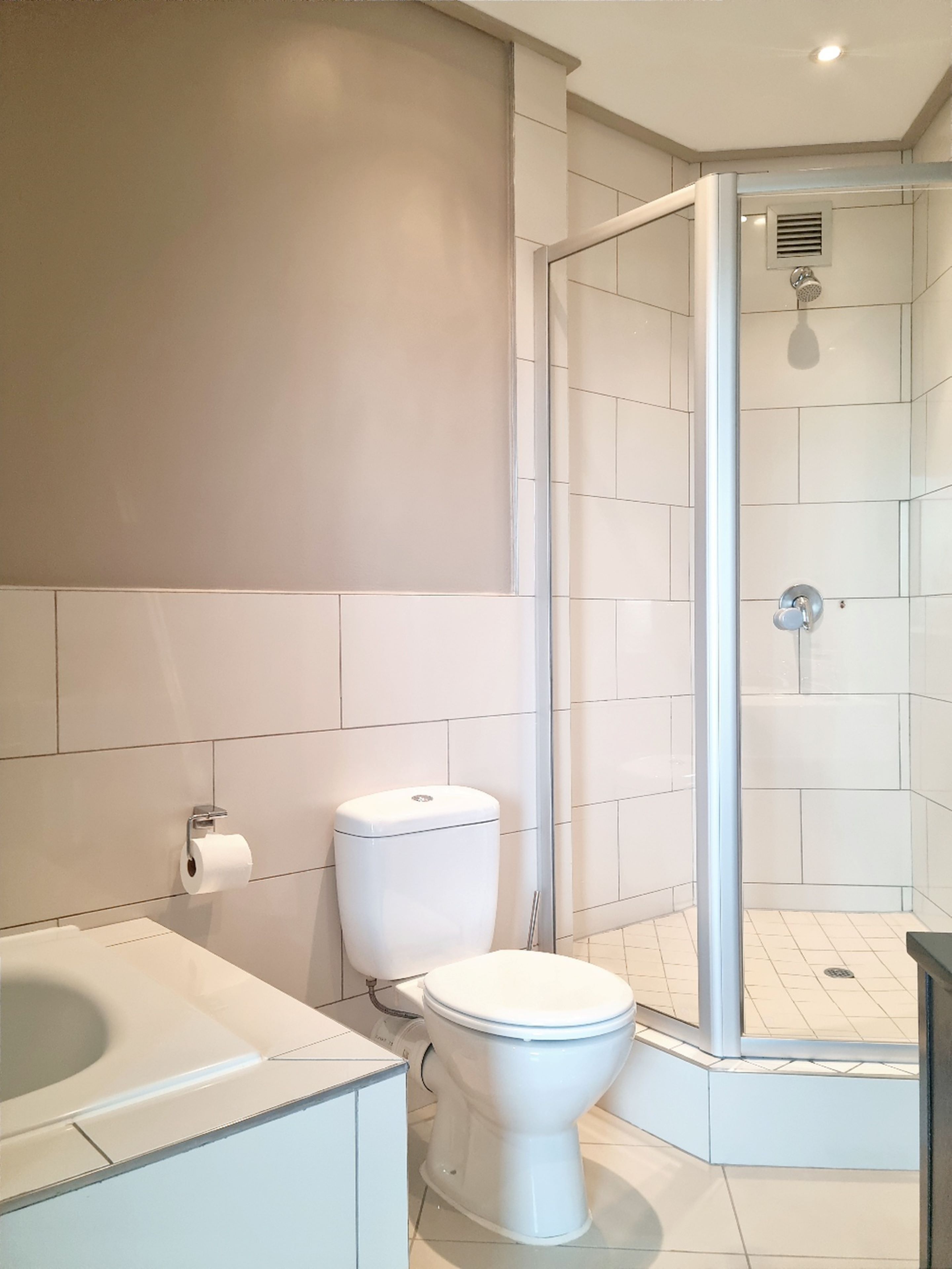 Ein modernes Badezimmer mit Toilette, Dusche und Badewanne.