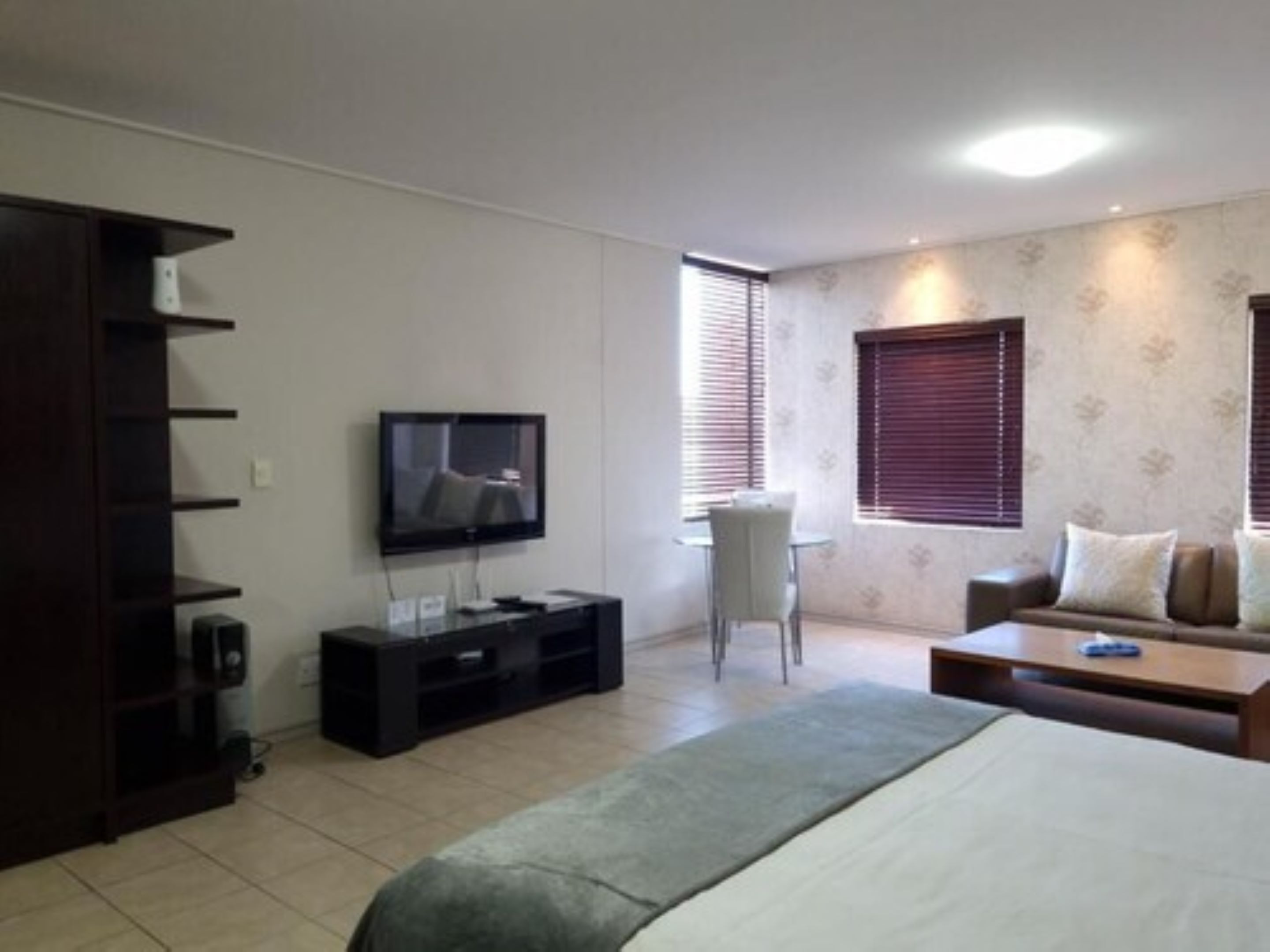 Una sala de estar moderna con una televisión de pantalla plana, un sofá, una mesa de centro y un mueble para la televisión.