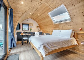 A cozy, wooden cabin-style room with a bed, a desk, and a window. - 0 bedroom accommodation in Great Busby (Great Busby)