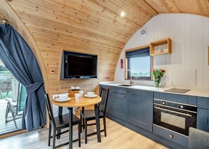 A compact kitchen with a dining area, wooden ceiling, and a TV mounted above the counter. - 0 bedroom accommodation in Great Busby (Great Busby)