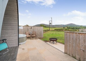A patio with a hot tub, chairs, and a barbecue grill. - 0 bedroom accommodation in Great Busby (Great Busby)