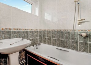A bathroom with a sink, bathtub, and shower. - Bungalow with one double and one single. (Trearddur Bay, Holyhead)