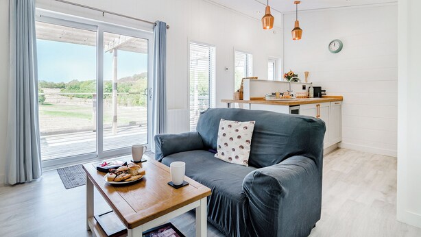 A modern living room with a sofa, a coffee table, and a view of the outdoors. - 1 bedroom accommodation in Cannington (Cannington)