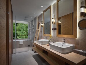 Ein modernes Badezimmer mit zwei Waschbecken, einem großen Spiegel und einer Duschkabine.