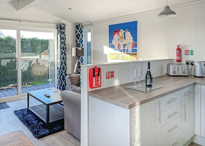 Uma cozinha moderna com uma ilha grande, uma sala de jantar com mesa e cadeiras, e vista para o exterior.