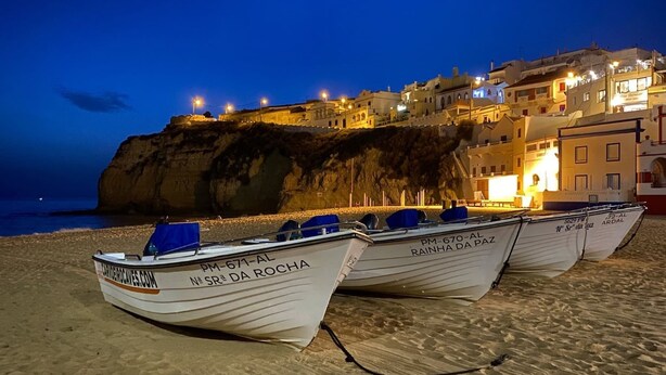 Boats lined up on a sandy beach with buildings in the background. - Carvoeiro Terrace - Gorgeous apartment close to beach (Carvoeiro)