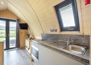 A compact kitchen with a built-in oven, a sink, and a window with blinds. - 1 bedroom accommodation in Great Busby (Great Busby)