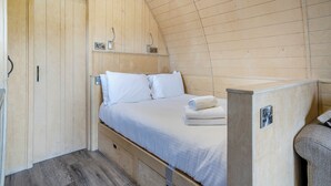 A wooden interior with a bed, a small table, and a wardrobe. - 1 bedroom accommodation in Great Busby (Great Busby)