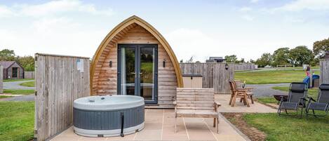 Une cabane en bois dotée d’un bain à remous, d’un espace détente sur la terrasse et d’une cour clôturée.