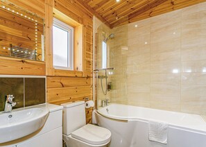 A wooden cabin bathroom with a sink, toilet, and bathtub. - Luxurious and contemporary Finnish log lodge. (Withernsea)